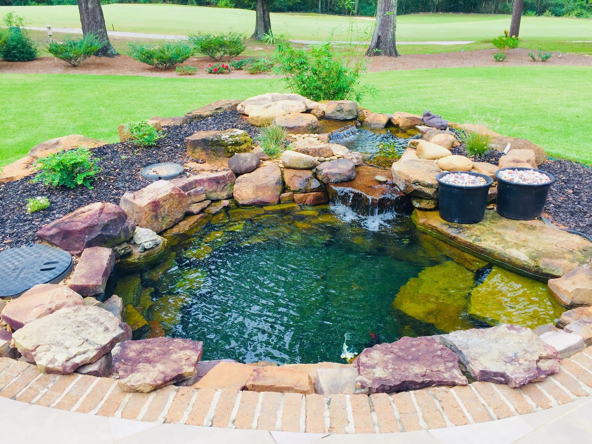 Bassin de jardin moderne à différents étages créant un jeu d’eau structuré et contemporain